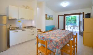 a kitchen and dining room with a table and a table and chairs at Villaggio Paradiso in Bibione