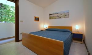 a bedroom with a bed and a large window at Villaggio Paradiso in Bibione +20 photos