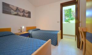 a bedroom with a blue bed and a window at Villaggio Paradiso in Bibione