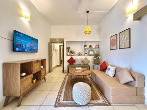 a living room with a couch and a tv at The Mango Tree by ANAND VILLA in Jodhpur