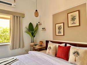 a bedroom with a bed with pillows and a window at The Mango Tree by ANAND VILLA in Jodhpur