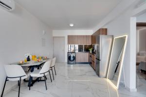a kitchen with a table and a stainless steel refrigerator at Oasis Luxury Residence B101 - Pool View in Xylophaghou