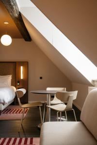 een slaapkamer met een bed, een tafel en stoelen bij Hotel Vrythof - just a room - digital key by email or SMS in Maastricht +13 foto's