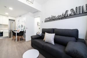 a living room with a black couch and a kitchen at Getafe Suites in Getafe +95 photos