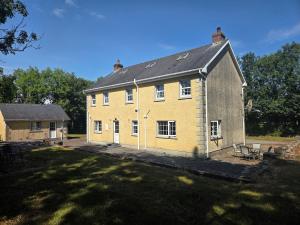 a large yellow house with a black roof at Lawnside Retreat in Mullinavat