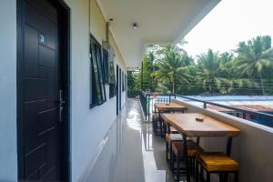 an open door to a balcony with tables and chairs at Urbanview keTemon Hotel & Resto YIA by RedDoorz in Yogyakarta