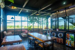 a restaurant with tables and chairs and windows at Urbanview keTemon Hotel & Resto YIA by RedDoorz in Yogyakarta
