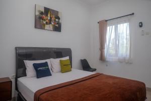 a bedroom with a bed with two pillows on it at Urbanview keTemon Hotel & Resto YIA by RedDoorz in Yogyakarta