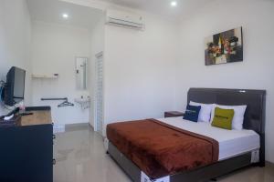 a bedroom with a bed and a television in it at Urbanview keTemon Hotel & Resto YIA by RedDoorz in Yogyakarta