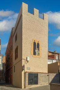 a person is looking out of the window of a building at La Casa del Miracle, hostal in Balaguer