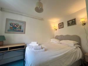 a bedroom with a white bed with towels on it at Mews Apartments in Lincoln