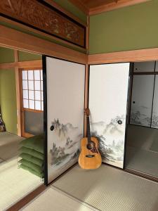 a guitar sitting on the corner of a room at JIKKA KYOTO MAIZURU Private - Kominka House for Groups & Families - Vacation STAY 21302 in Kuradani