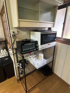 a kitchen with a microwave and a toaster oven at JIKKA KYOTO MAIZURU Private - Kominka House for Groups & Families - Vacation STAY 21302 in Kuradani