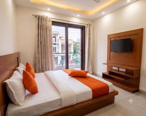 a bedroom with a bed with a window and a television at Hotel Retro Folic Near Golf Course Road & Cyber City in Gurgaon