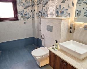 a bathroom with a white sink and a toilet at Hotel Retro Folic Near Golf Course Road & Cyber City in Gurgaon +22 photos