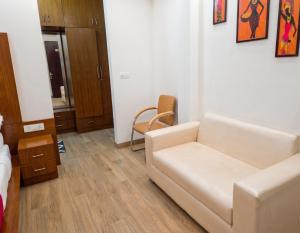 a living room with a white couch and a chair at Hotel Retro Folic Near Golf Course Road & Cyber City in Gurgaon