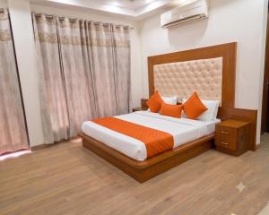 a bedroom with a large bed with orange pillows at Hotel Retro Folic Near Golf Course Road & Cyber City in Gurgaon