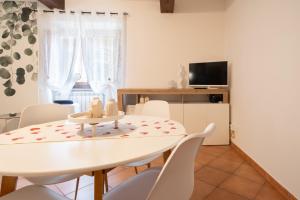 a white dining room with a white table and chairs at A Cuor Leggero Home in Viterbo