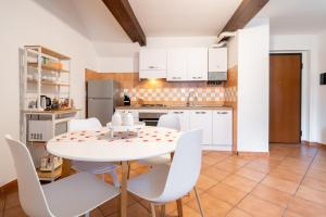 a kitchen with a white table and white chairs at A Cuor Leggero Home in Viterbo