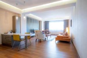a living room with a table and chairs at Heykel Suites Otel in Konak