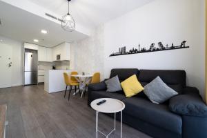 a living room with a blue couch and a table at Getafe Suites in Getafe