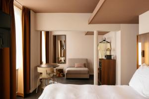 een hotelkamer met een bed, een bureau en een stoel bij Hotel Vrythof - just a room - digital key by email or SMS in Maastricht
