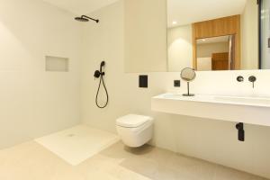 a white bathroom with a toilet and a sink at Ocean Drive Málaga - New Opening 2026 in Málaga