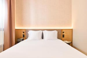 a large bed with white pillows in a hotel room at Ocean Drive Málaga - New Opening 2026 in Málaga