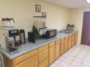 a kitchen with a counter with a microwave and a sink at Americas Best Value Inn Evansville East in Evansville