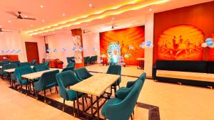 a banquet hall with tables and chairs and a painting at Hotel De - Grand Villa Near Delhi IGI Airport in New Delhi