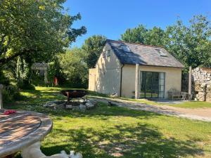 a backyard with a barbecue and a building at Tresahor Studio with sauna in Falmouth