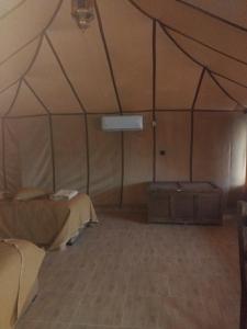 a room with a tent with a bed in it at Merzouga camelle trike bivoage in Merzouga