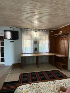 a room with a table and a tv on the wall at Cazare-LaBadeaMircea in Soroca