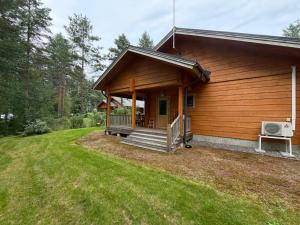 a log cabin with a porch and a deck at Villa Lena in Kouvola