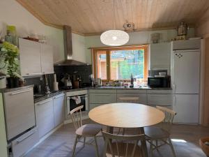 a kitchen with a wooden table and a table and chairs at Villa Lena in Kouvola