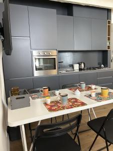 a kitchen with a table with chairs and a microwave at Ver Sacrum - Appartamento in centro in Ascoli Piceno