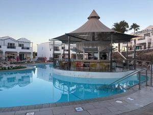 a large swimming pool with a gazebo in a resort at Turbo Club in Maspalomas