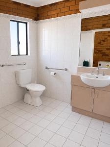 un bagno bianco con WC e lavandino di Boulder Opal Motor Inn a Winton