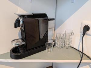 a microwave sitting on top of a shelf with glasses at Dieu Bé Nice in Nice