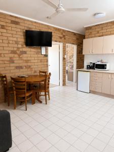 una cucina e una sala da pranzo con tavolo e sedie di Boulder Opal Motor Inn a Winton