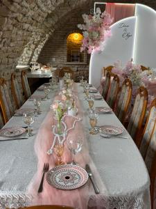 a long table with plates and wine glasses on it at Cazare-LaBadeaMircea in Soroca +23 photos