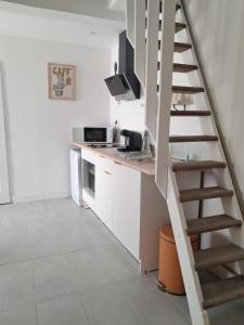 a kitchen with a spiral staircase in a room at Chemin du vieux Puits in Surgères