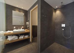 a bathroom with a sink and a shower at Hotel Vajolet in San Cassiano +39 photos