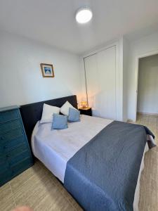 a bedroom with a large bed with blue pillows at Aquamarine home in Campoamor
