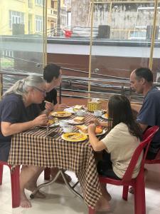 a group of people sitting at a table eating food at Grand Ireland hotel in Cat Ba