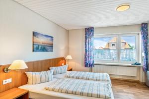 a bedroom with two beds and a window at Hotel Zum Wikinger - Haustiere in Dornum