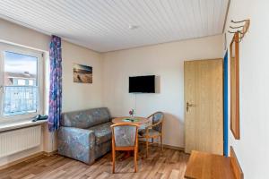 a living room with a couch and a table at Hotel Zum Wikinger - Haustiere in Dornum