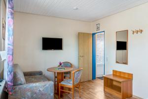 a living room with a table and a chair at Hotel Zum Wikinger - Haustiere in Dornum +15 photos