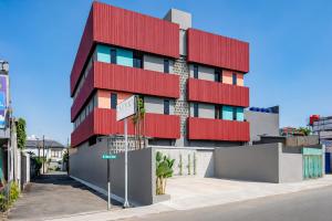 a red building on the side of a street at Sans Stay Bintaro in Pondoklang