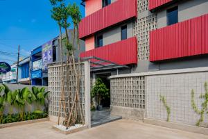 a facade of a building with red and white at Sans Stay Bintaro in Pondoklang +17 photos